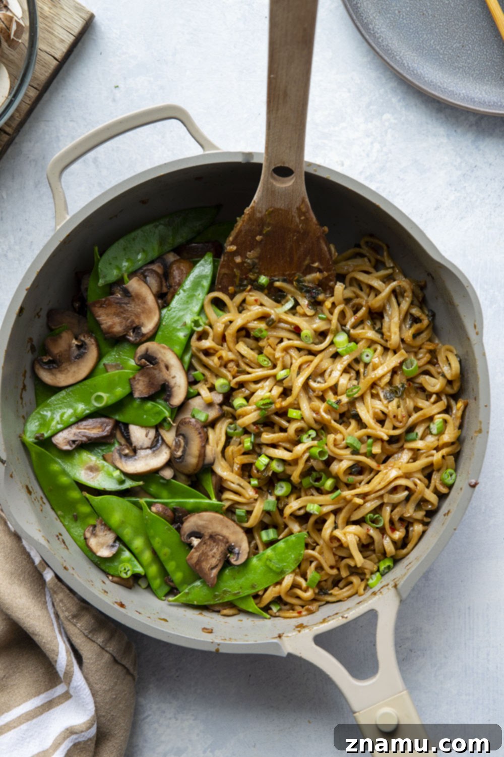 Fiery Miso Scallion Noodles 3 Overhead shot of a skillet filled with freshly cooked spicy miso noodles, featuring green scallions, red pepper flakes, and glistening sauce.