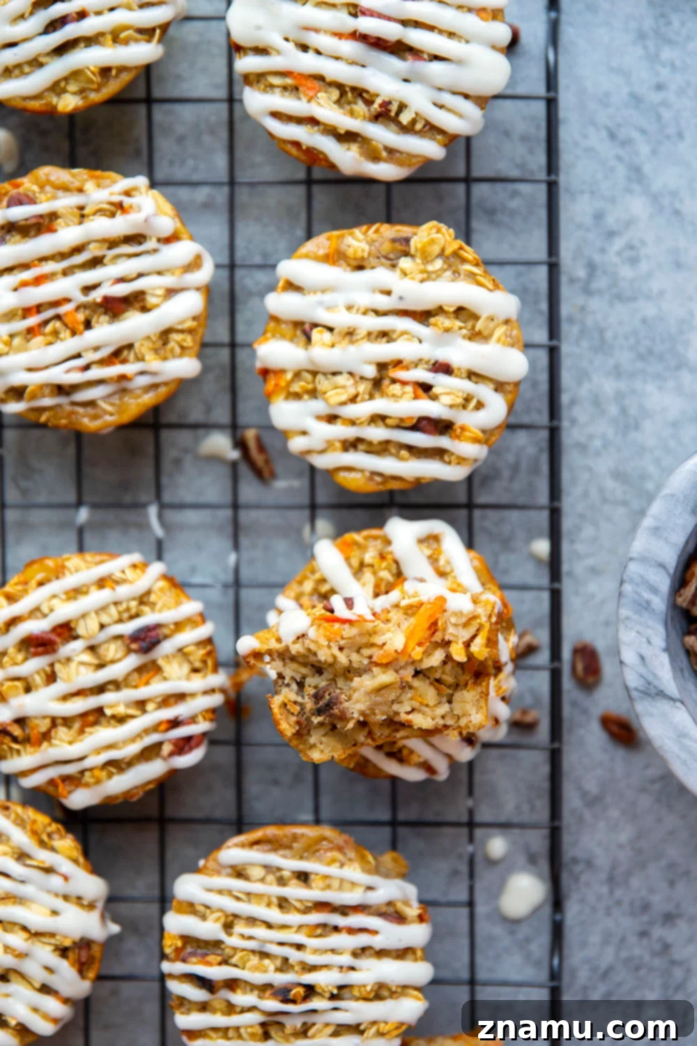 Breakfast Carrot Cake Oatmeal Cups 5 A Carrot Cake Baked Oatmeal Cup with glaze, being held, showing its moist and wholesome texture.