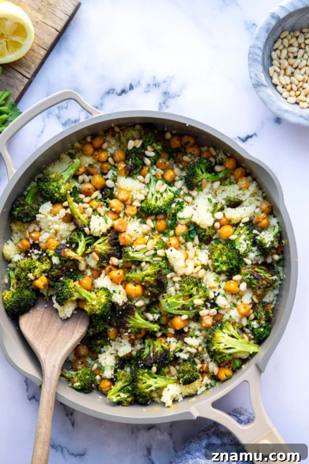 Zesty Lemon Couscous with Roasted Broccoli and Chickpeas 3 Close-up of vibrant Lemon Couscous featuring roasted broccoli and crispy chickpeas, garnished with fresh parsley.
