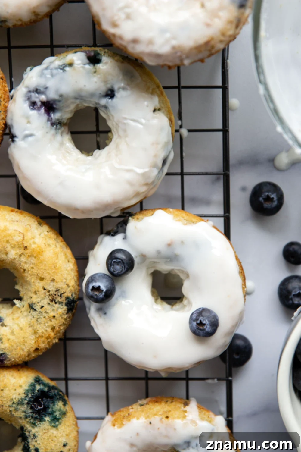 Blueberry Banana Vanilla Donuts 4 Single baked blueberry banana donut resting on a wire rack, showcasing its texture and ready for the next step of glazing.