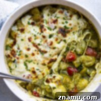 Baked with two kinds of cheese on top with lots of tender zucchini and cherry tomatoes, this cheesy baked pesto gnocchi uses basic pantry ingredients and is ready in under an hour!
