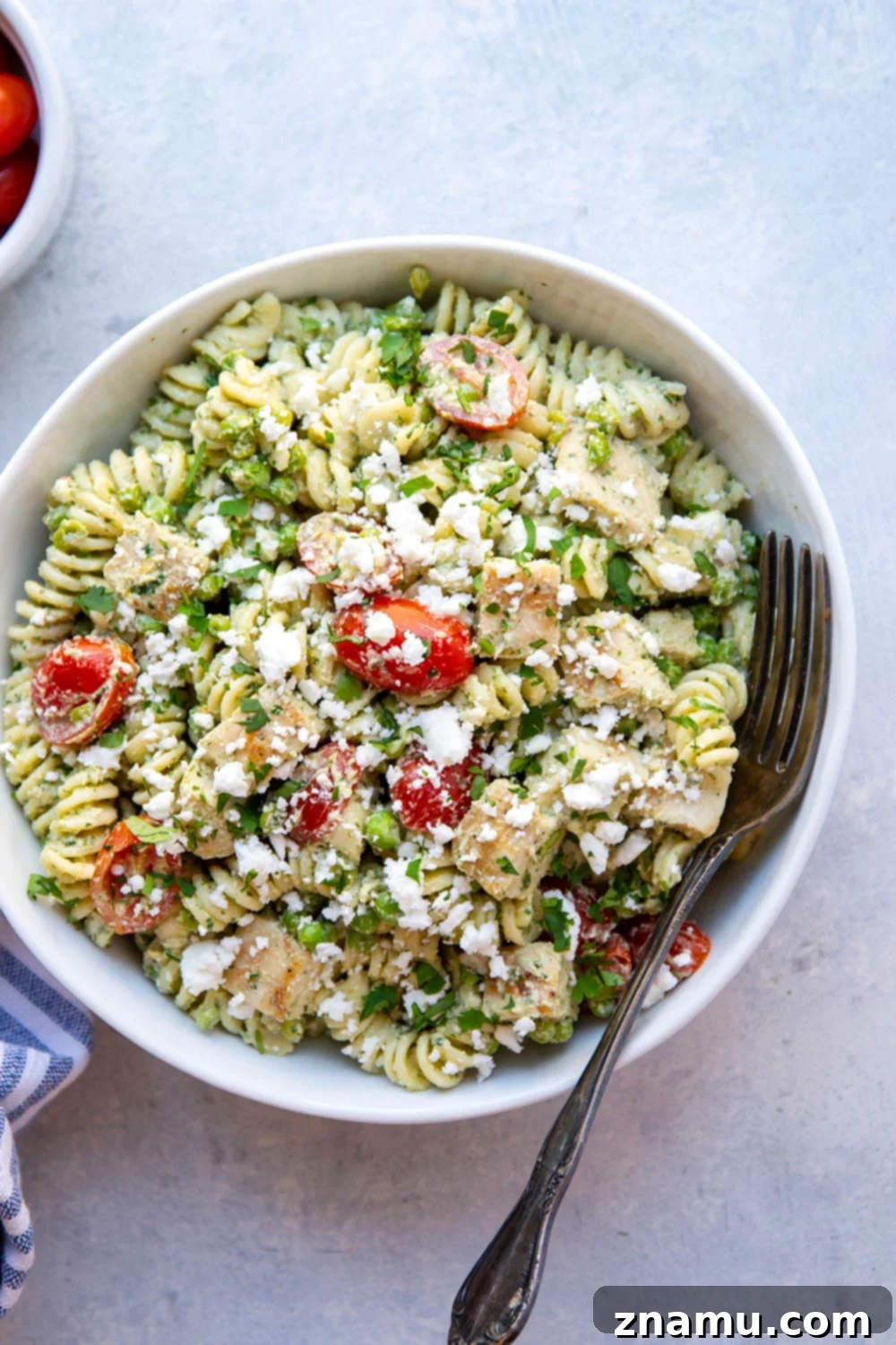 Green Goddess Pasta Salad: Feta & Grilled Chicken 4 A vibrant bowl of green goddess pasta salad with fresh herbs, grilled chicken, and cherry tomatoes.