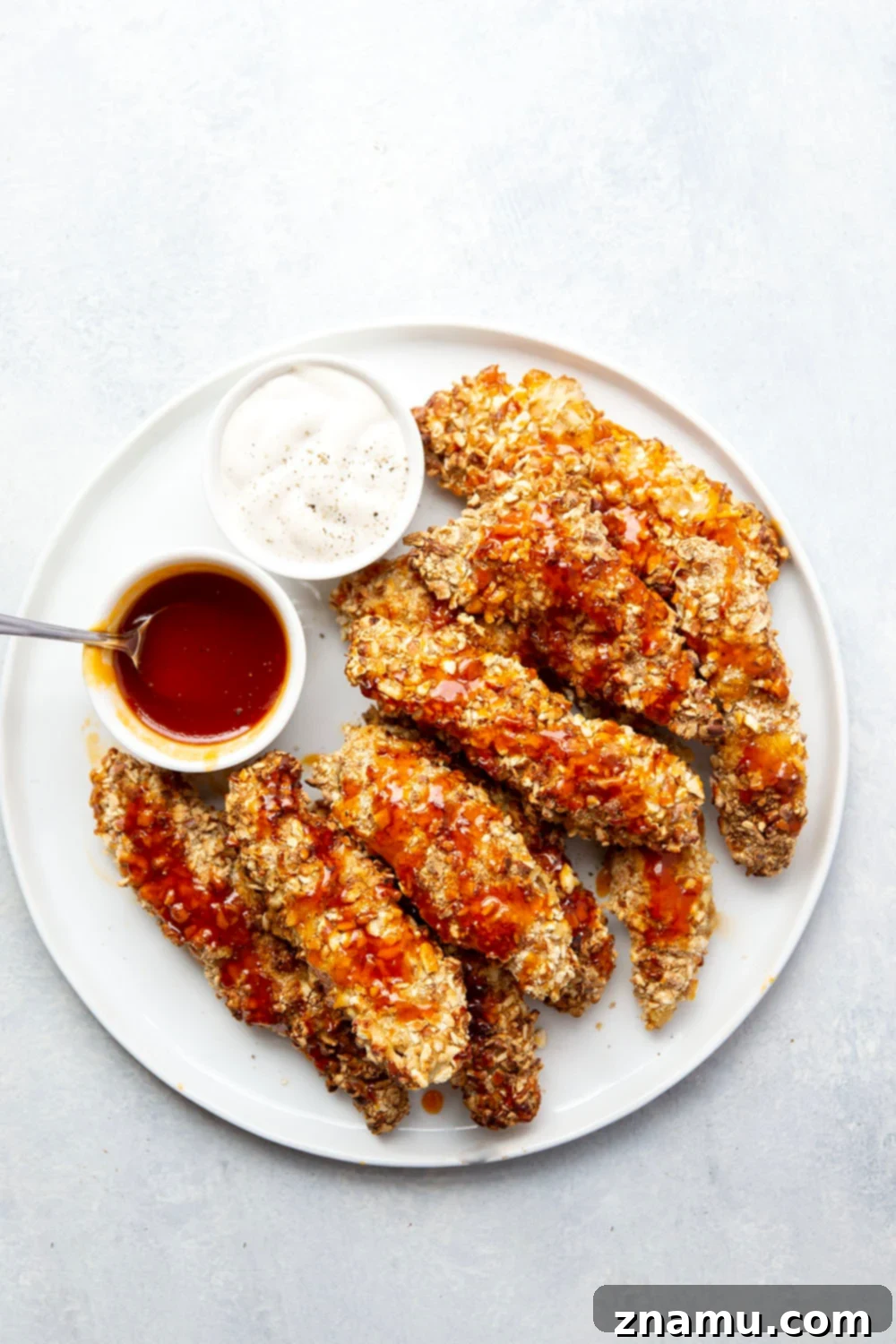 Air Fryer Crispy Pretzel Chicken with Hot Honey Glaze 3 Close-up of golden brown air fryer pretzel crusted chicken tenders on a cooling rack.
