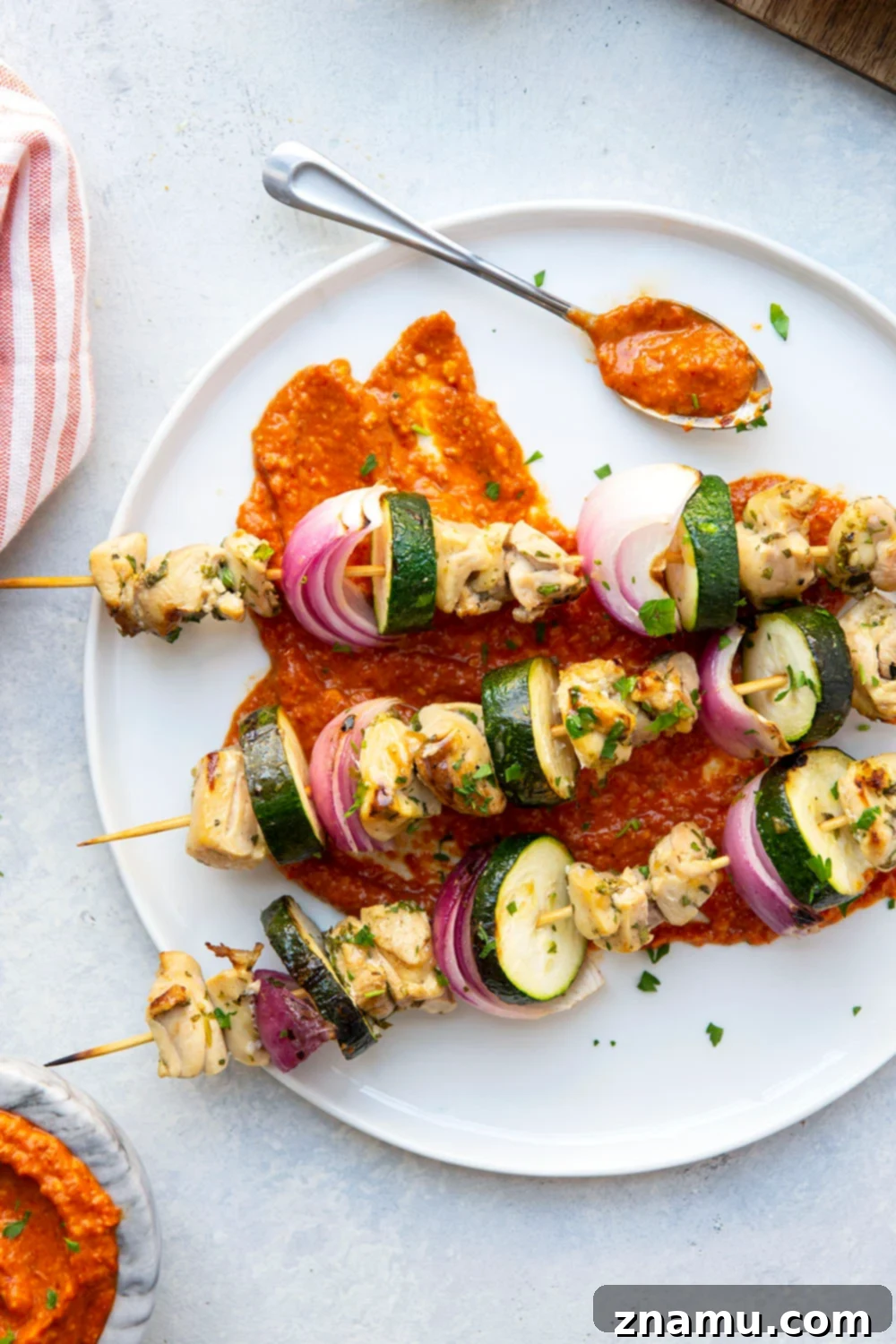 Sun-Kissed Chicken Skewers with Smoky Romesco 2 Grilled Lemon Garlic Chicken Kabobs with Romesco Sauce on a Plate, ready to serve