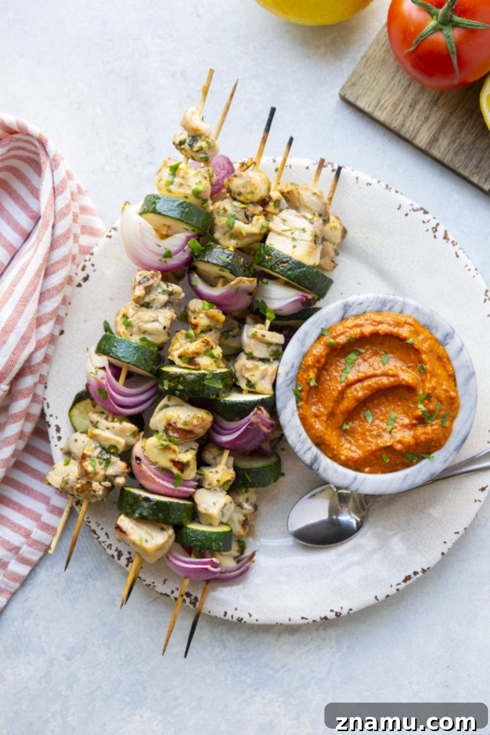 Sun-Kissed Chicken Skewers with Smoky Romesco 6 Full spread of Lemon Garlic Chicken Kabobs, Romesco, and side dishes like rice and bread