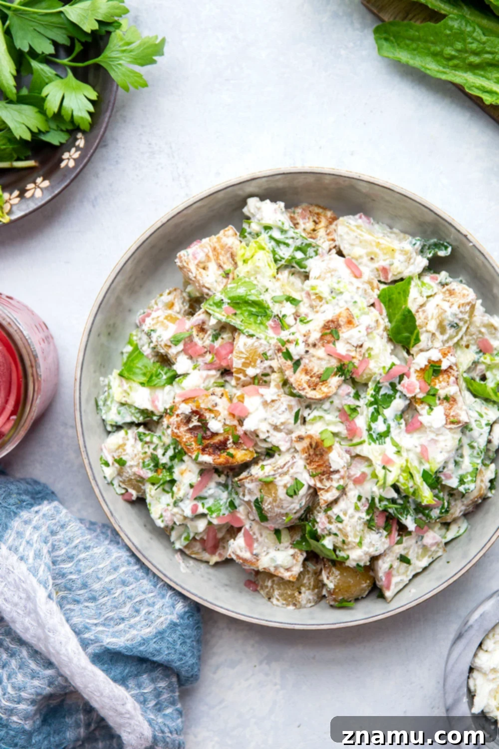 Mediterranean Tzatziki Potato Salad 2 This Greek tzatziki potato salad features tender herb-roasted potatoes dressed with homemade tzatziki sauce and tossed with lots of crisp lettuce, crumbly feta, and pickled red onions.