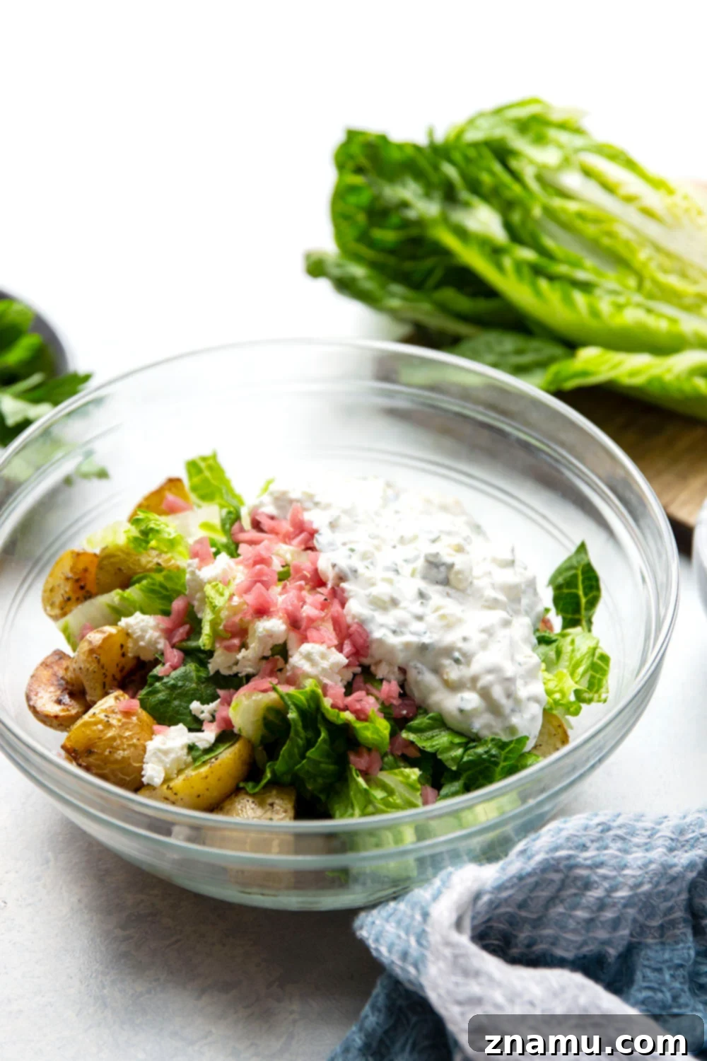 Mediterranean Tzatziki Potato Salad 4 This Greek tzatziki potato salad features tender herb-roasted potatoes dressed with homemade tzatziki sauce and tossed with lots of crisp lettuce, crumbly feta, and pickled red onions.