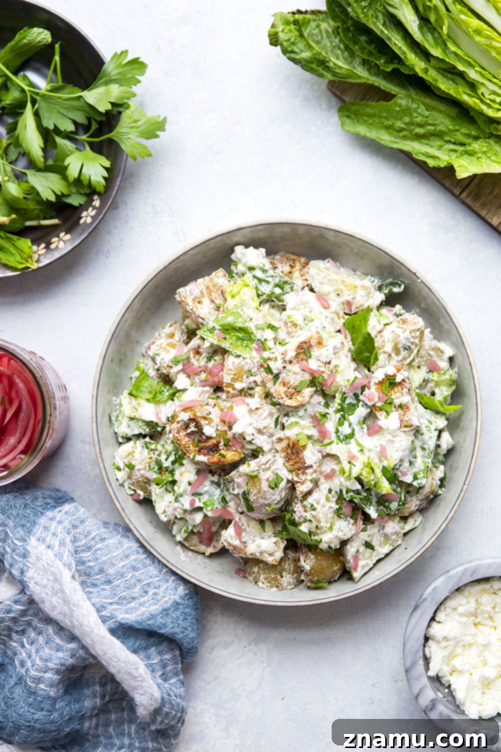 Mediterranean Tzatziki Potato Salad 5 This Greek tzatziki potato salad features tender herb-roasted potatoes dressed with homemade tzatziki sauce and tossed with lots of crisp lettuce, crumbly feta, and pickled red onions.