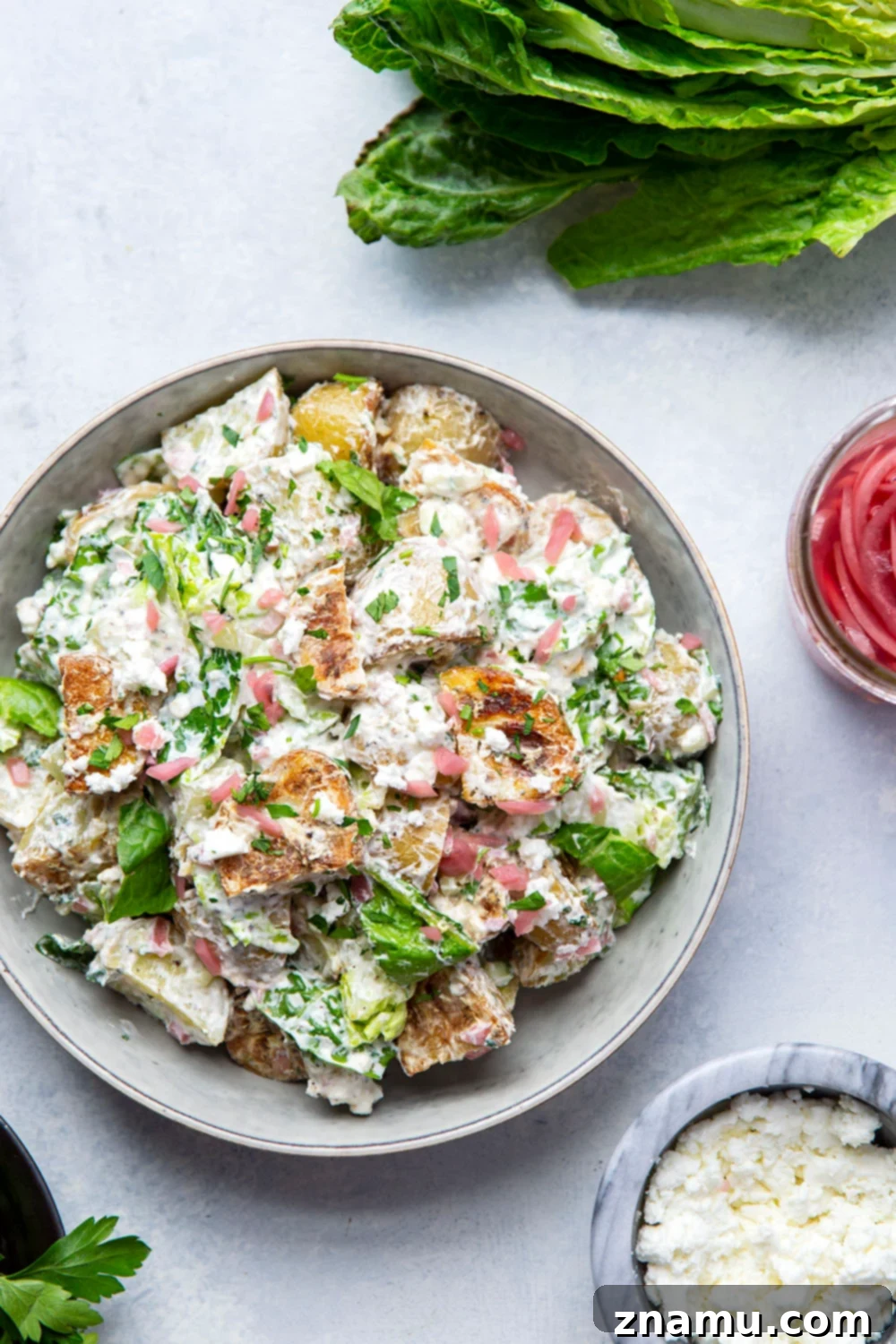 Mediterranean Tzatziki Potato Salad 6 This Greek tzatziki potato salad features tender herb-roasted potatoes dressed with homemade tzatziki sauce and tossed with lots of crisp lettuce, crumbly feta, and pickled red onions.