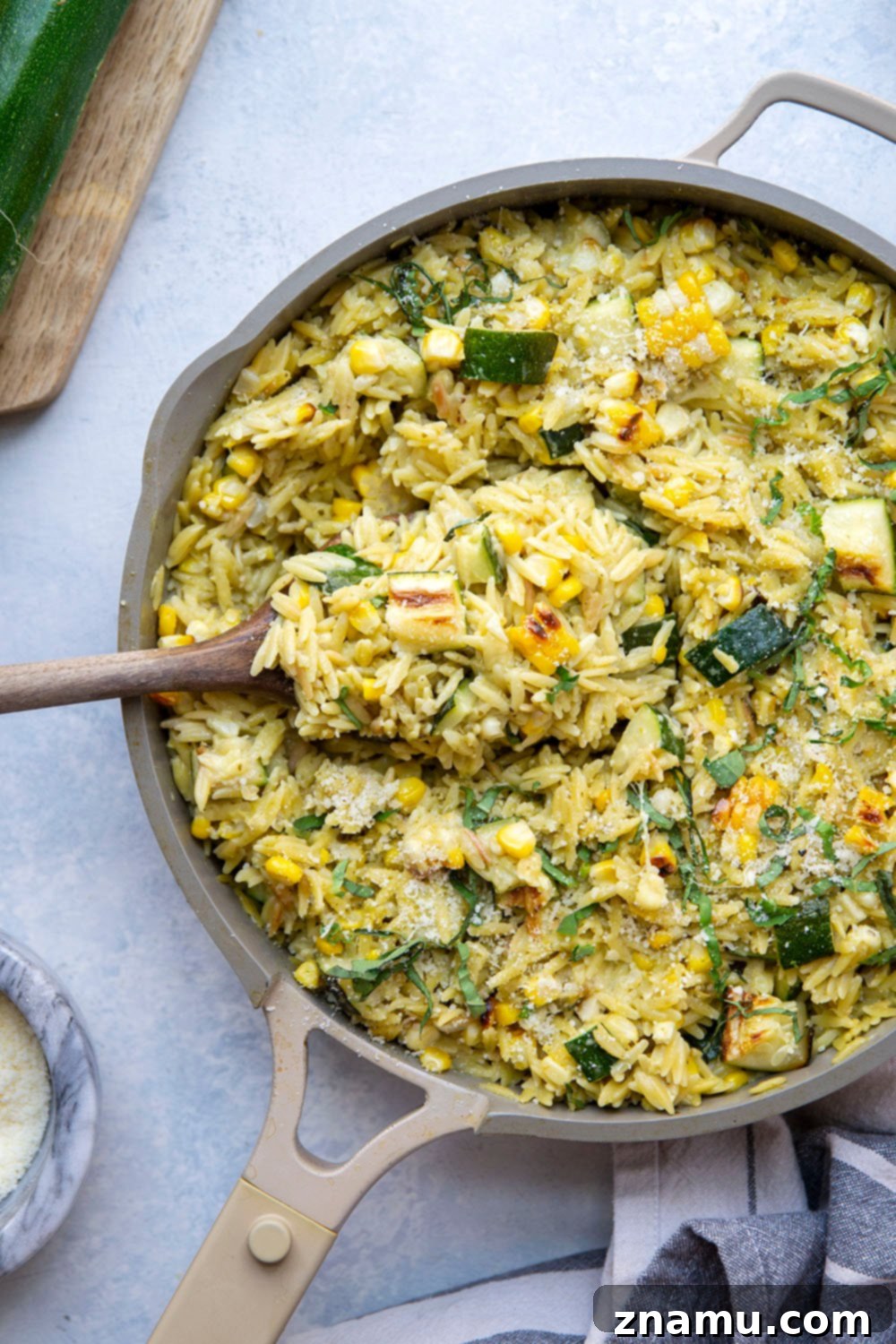 Grilled Zucchini & Sweet Corn Pesto Orzo 4 A vibrant bowl of Pesto Zucchini Orzo, garnished with fresh basil and grated Parmesan