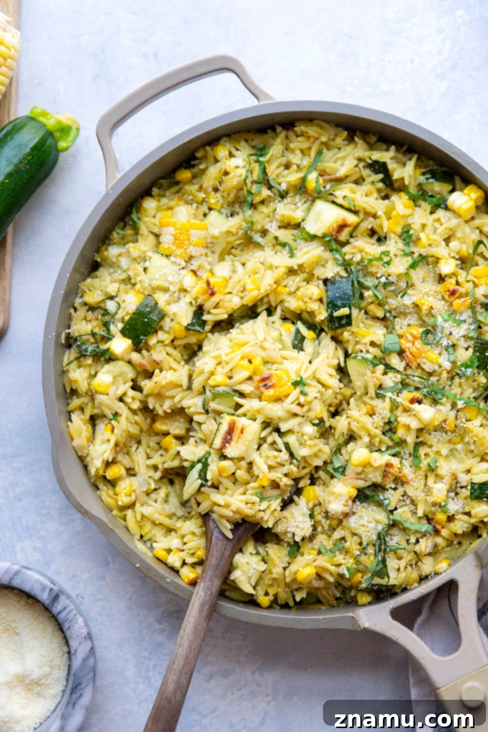 Grilled Zucchini & Sweet Corn Pesto Orzo 6 A serving of Pesto Zucchini Orzo with a fork, ready to be enjoyed