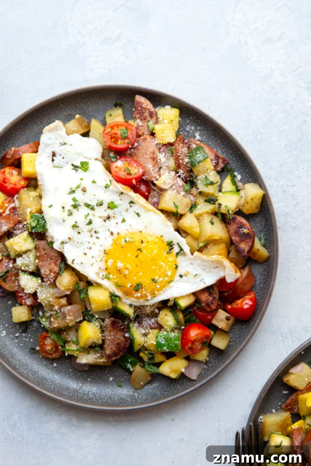 Summer Harvest Sausage Hash 2 This sausage breakfast hash is loaded with a rainbow of fresh summer vegetables, crispy potatoes, and lots of flavorful sausage. - the best savory summer breakfast with an egg served on top!