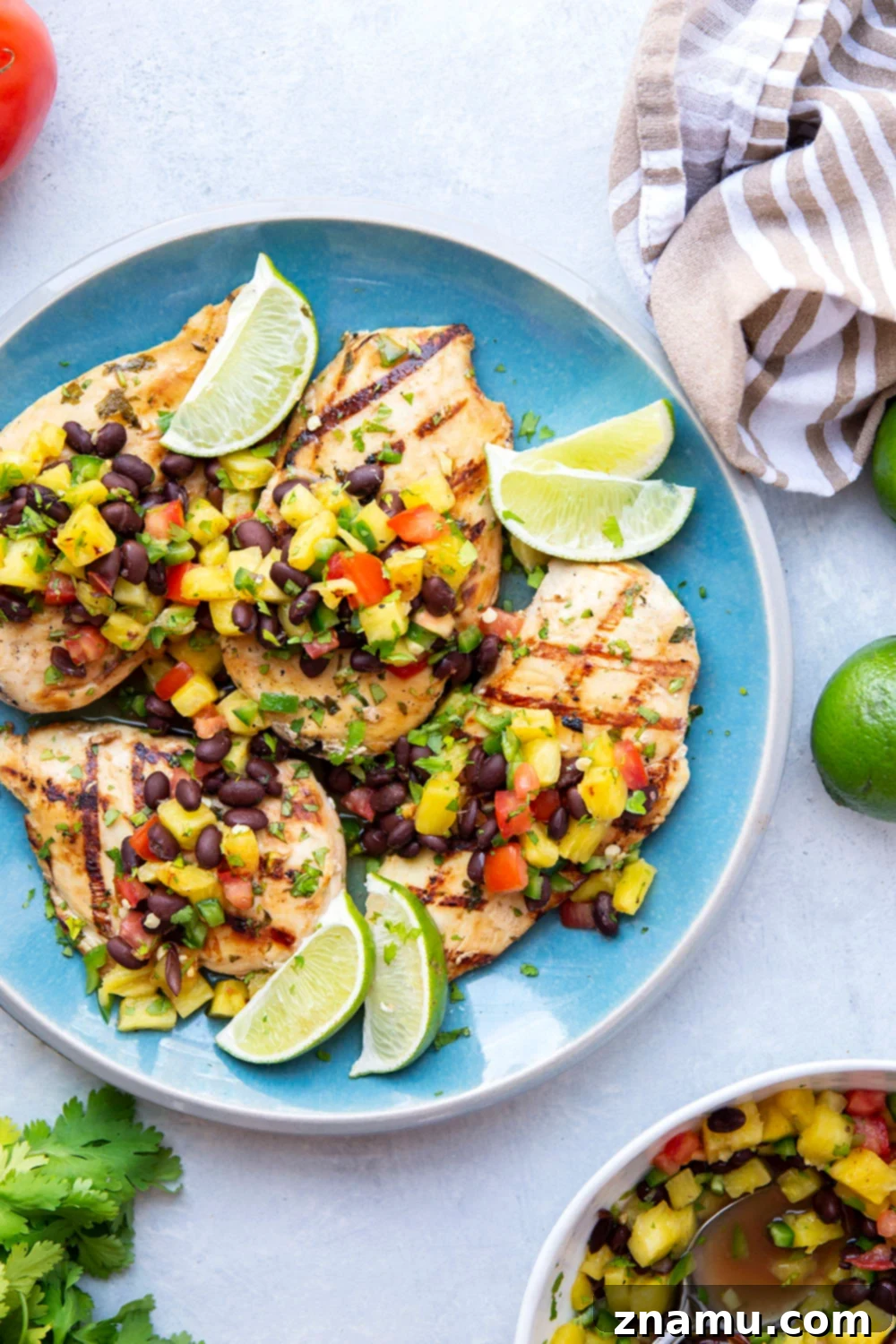 Pineapple Grilled Chicken with Fresh Black Bean Salsa 6 A serving of pineapple grilled chicken topped with black bean salsa, ready to be enjoyed.