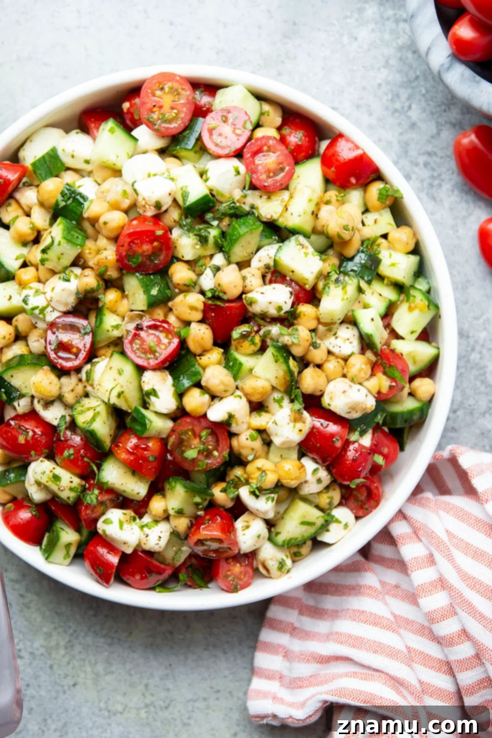 Roasted Garlic Basil Caprese Chickpea Salad 2 A vibrant Caprese Chickpea Salad with crisp cucumber, juicy cherry tomatoes, fresh mozzarella pearls, and tender chickpeas, all coated in a rich, herby roasted garlic basil dressing. Perfect for summer.