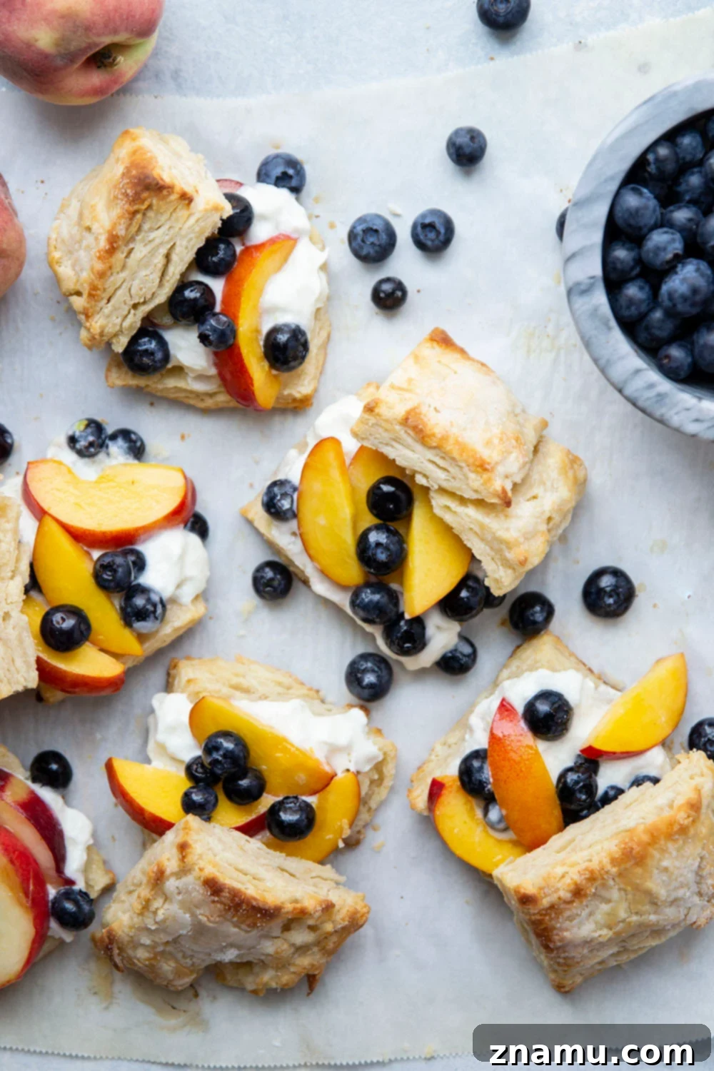 Sun-Drenched Peach Berry Dream 5 A bowl filled with fresh, juicy peaches and blueberries, perfectly macerated and ready to be used as a filling for a delicious summer shortcake.
