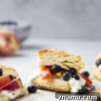 Juicy summer peaches and blueberries are incredible tucked between flaky homemade biscuits with plenty of whipped cream in this summery shortcake!