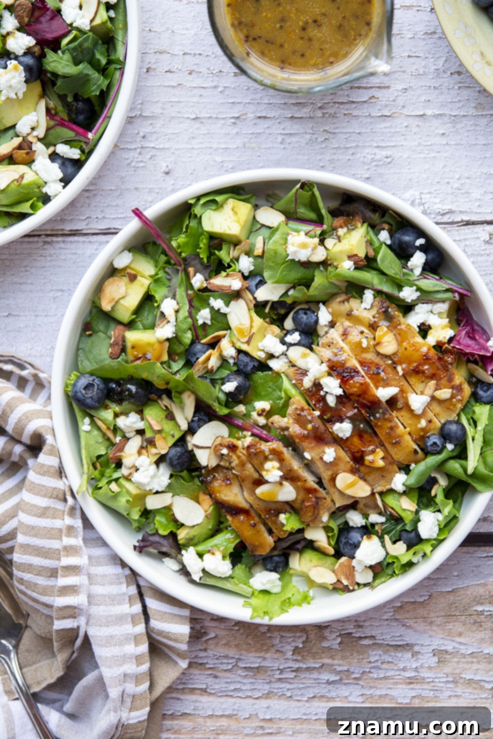 This salad features juicy grilled chicken thighs brushed with homemade honey mustard and tossed in a big green salad with fresh blueberries and avocado.