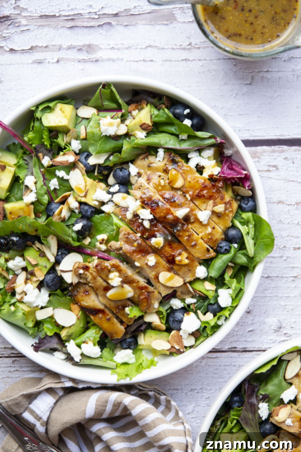 This salad features juicy grilled chicken thighs brushed with homemade honey mustard and tossed in a big green salad with fresh blueberries and avocado.
