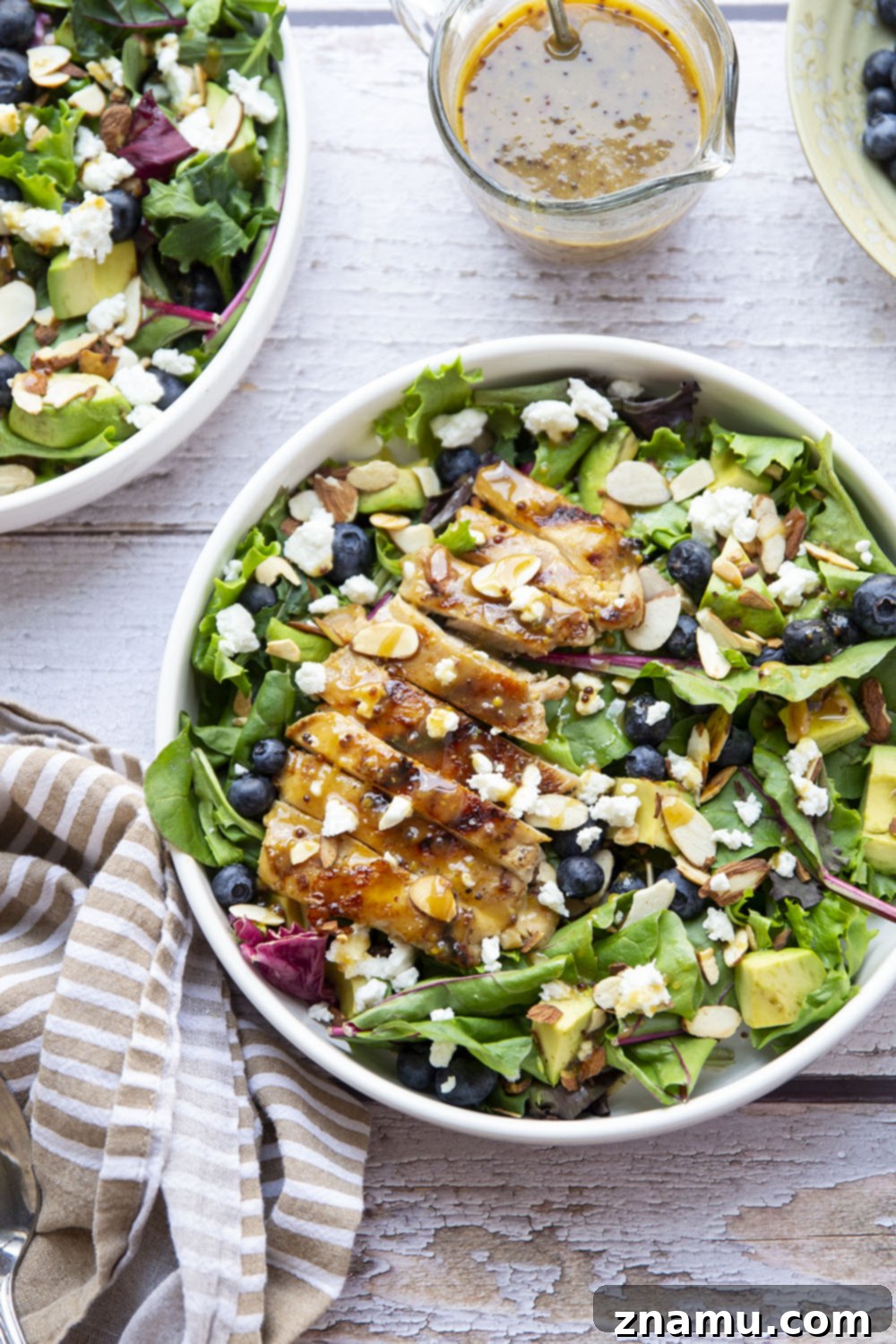 This salad features juicy grilled chicken thighs brushed with homemade honey mustard and tossed in a big green salad with fresh blueberries and avocado.