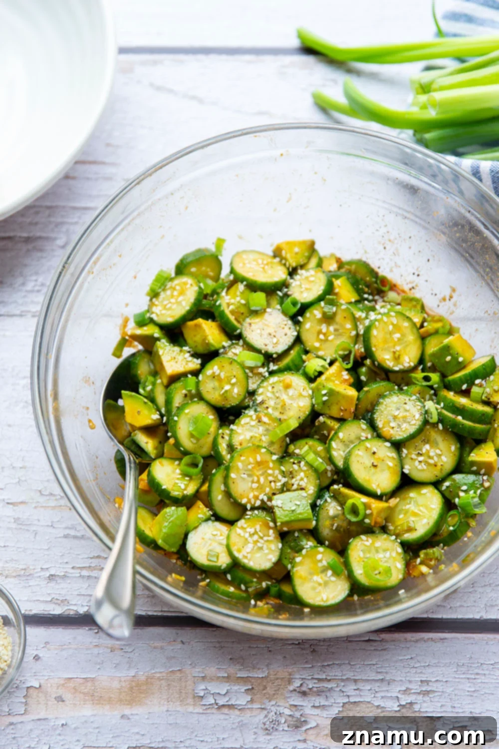 Vibrant Asian Cucumber Avocado Medley 2 Vibrant Asian Cucumber Avocado Salad with gochujang dressing, featuring crisp green cucumbers and creamy avocado chunks.