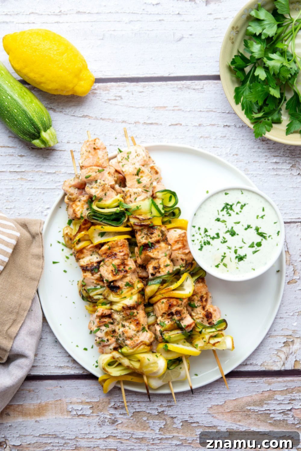Mediterranean Salmon Skewers with Whipped Feta 4 A plate of Greek grilled salmon kabobs, ready to be served, with the whipped feta sauce in the background.