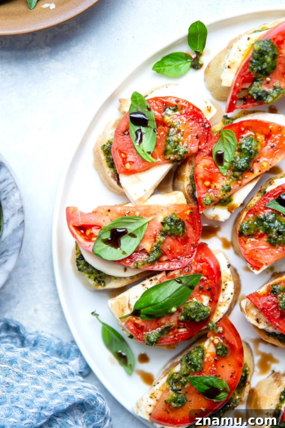 Fresh Basil Pesto Caprese Bruschetta 2 Fresh Caprese Bruschetta with homemade basil pesto, vibrant tomatoes, and creamy mozzarella on toasted bread