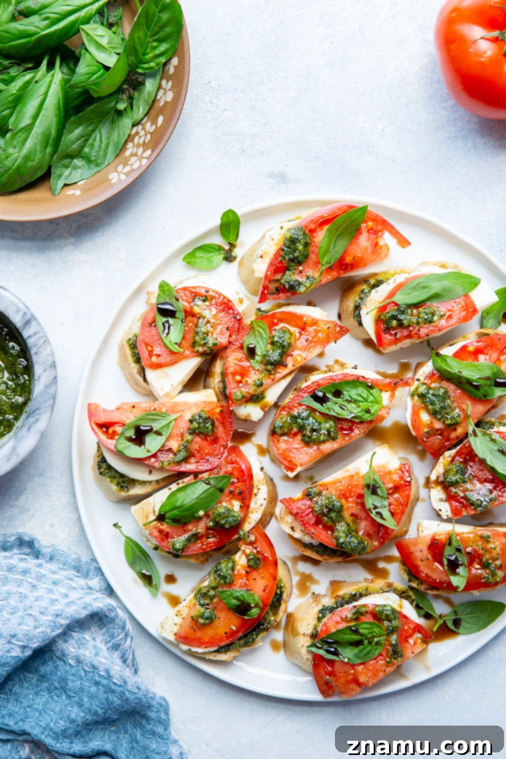 Fresh Basil Pesto Caprese Bruschetta 6 Finished Caprese Bruschetta with balsamic glaze, arranged on a rustic board