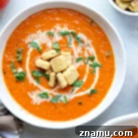 Crimson Fire-Roasted Tomato & Pepper Bisque 8 A small image of creamy roasted red pepper tomato soup with basil garnish.