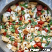 Caprese Chicken Skillet 8 A vibrant image of the Skillet Caprese Chicken Bites in the pan, showcasing the melted cheese and fresh herbs, ready to be eaten.