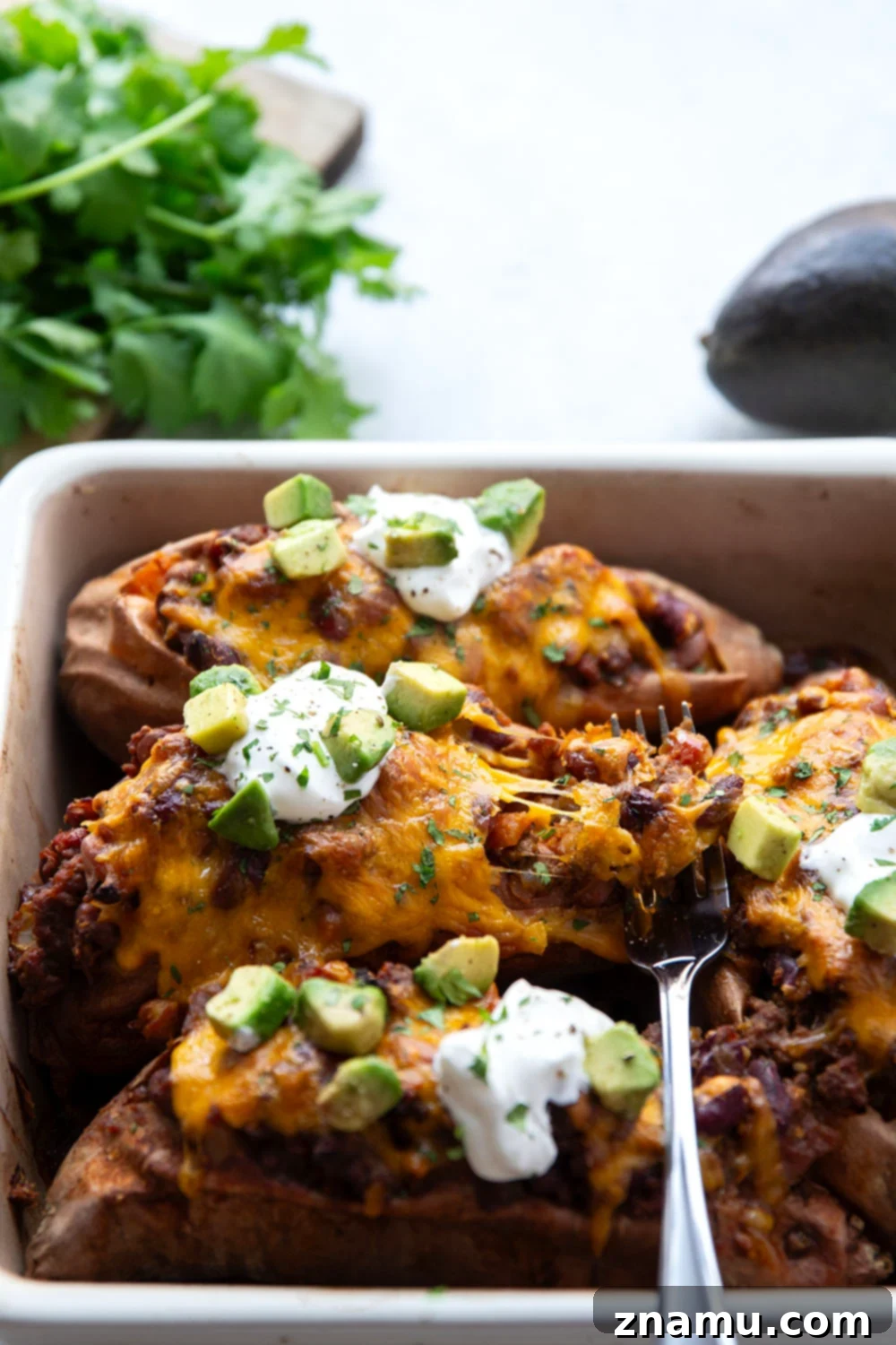 Ultimate Cheesy Chili Sweet Potatoes 3 Stuffed sweet potatoes with rich beef and bean chili, topped with melted cheddar cheese for a wholesome and satisfying meal.