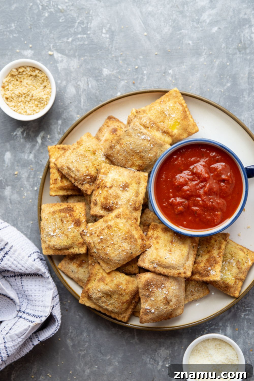 Crispy Air Fryer Ravioli 5 Several Air Fryer Toasted Ravioli pieces being dipped into a bowl of marinara sauce.