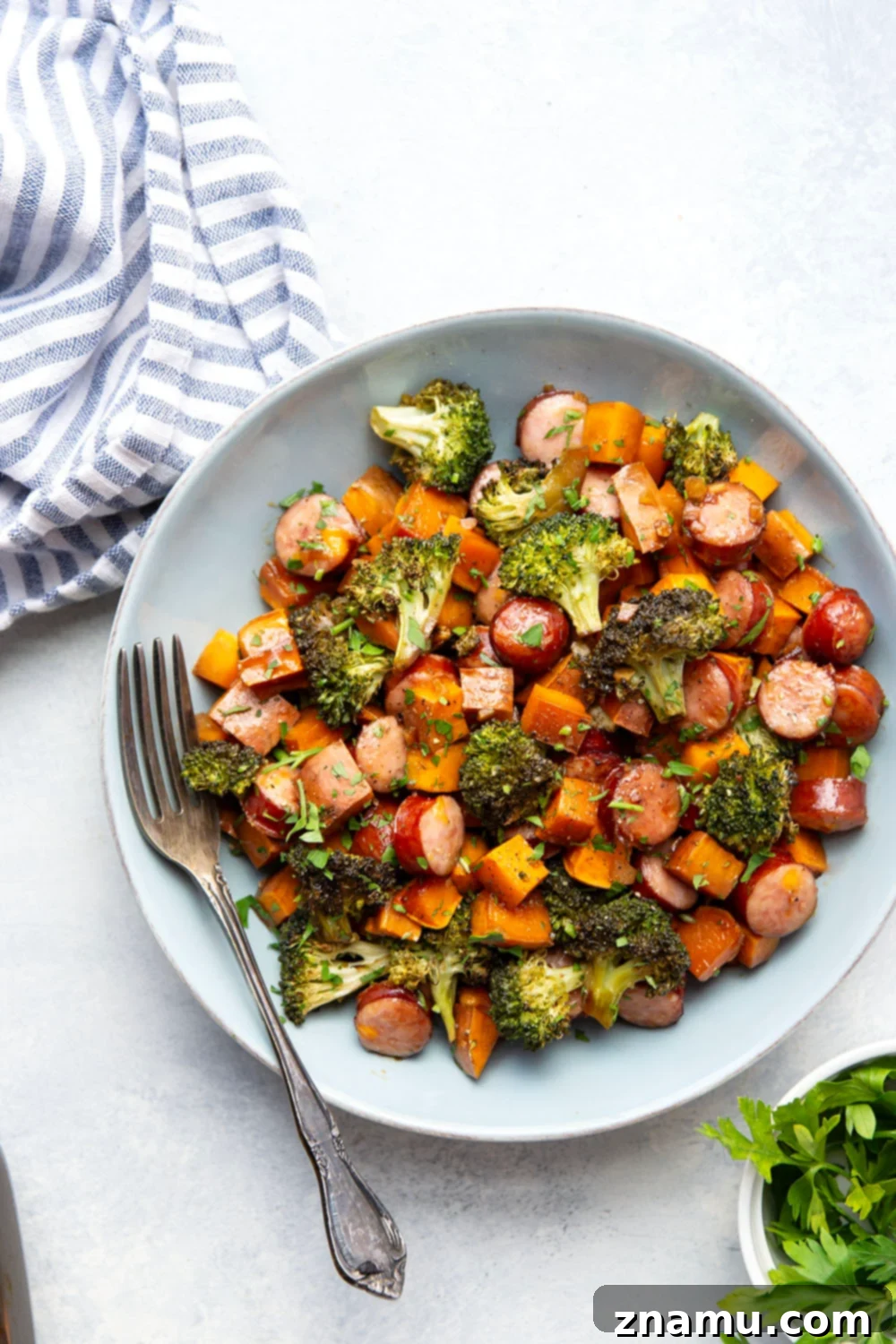 Sticky Honey Garlic Sheet Pan Sausage and Sweet Potatoes 4 A vibrant close-up of honey garlic glazed sweet potatoes, broccoli, and sausage, ready for roasting.