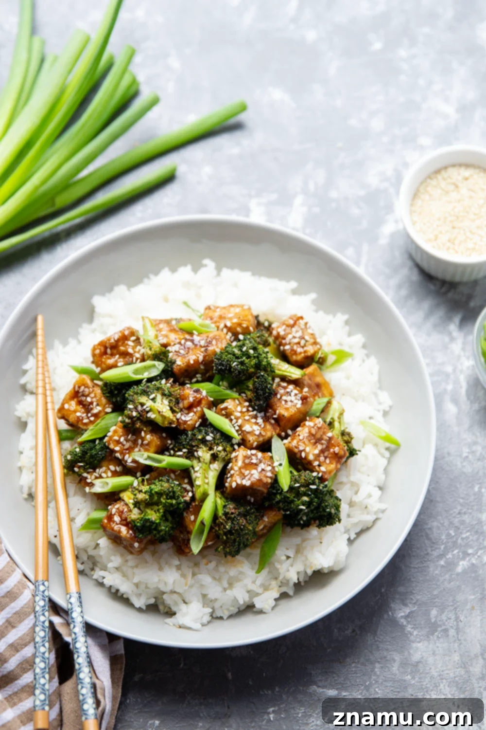 Perfectly Crispy Air Fryer Sesame Tofu and Broccoli 2 Crispy Air Fryer Sesame Tofu and Broccoli served over rice, garnished with green onions and sesame seeds.