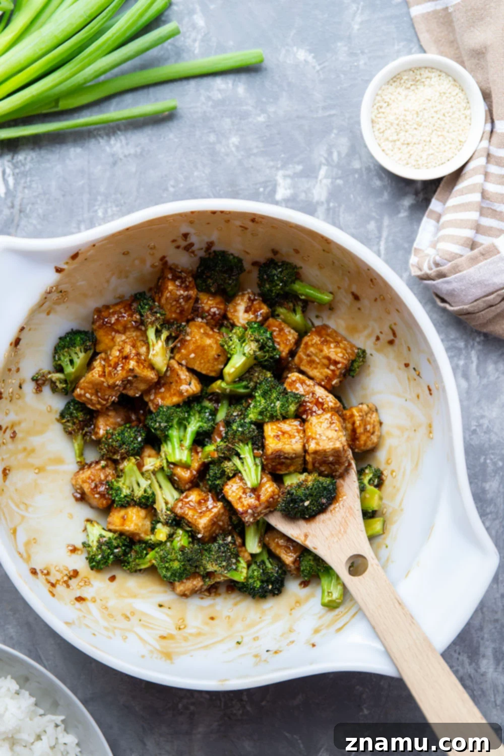 Perfectly Crispy Air Fryer Sesame Tofu and Broccoli 3 Close-up of crispy sesame tofu and tender broccoli florets from the air fryer, glistening with sesame sauce.