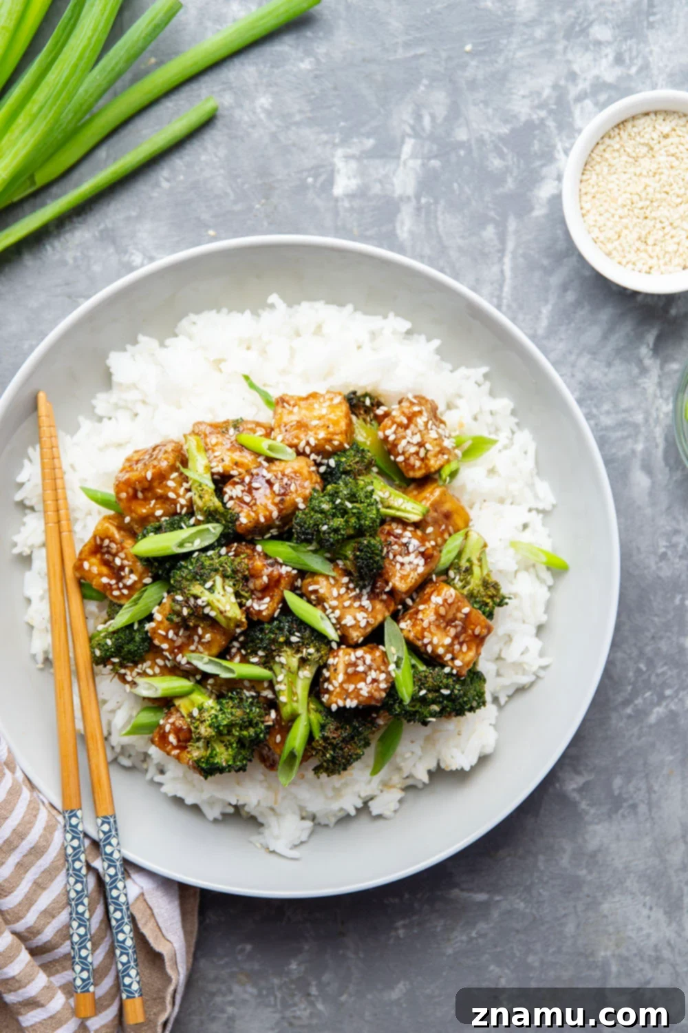 Perfectly Crispy Air Fryer Sesame Tofu and Broccoli 6 A close-up of a serving of Air Fryer Sesame Tofu and Broccoli, garnished with sesame seeds.