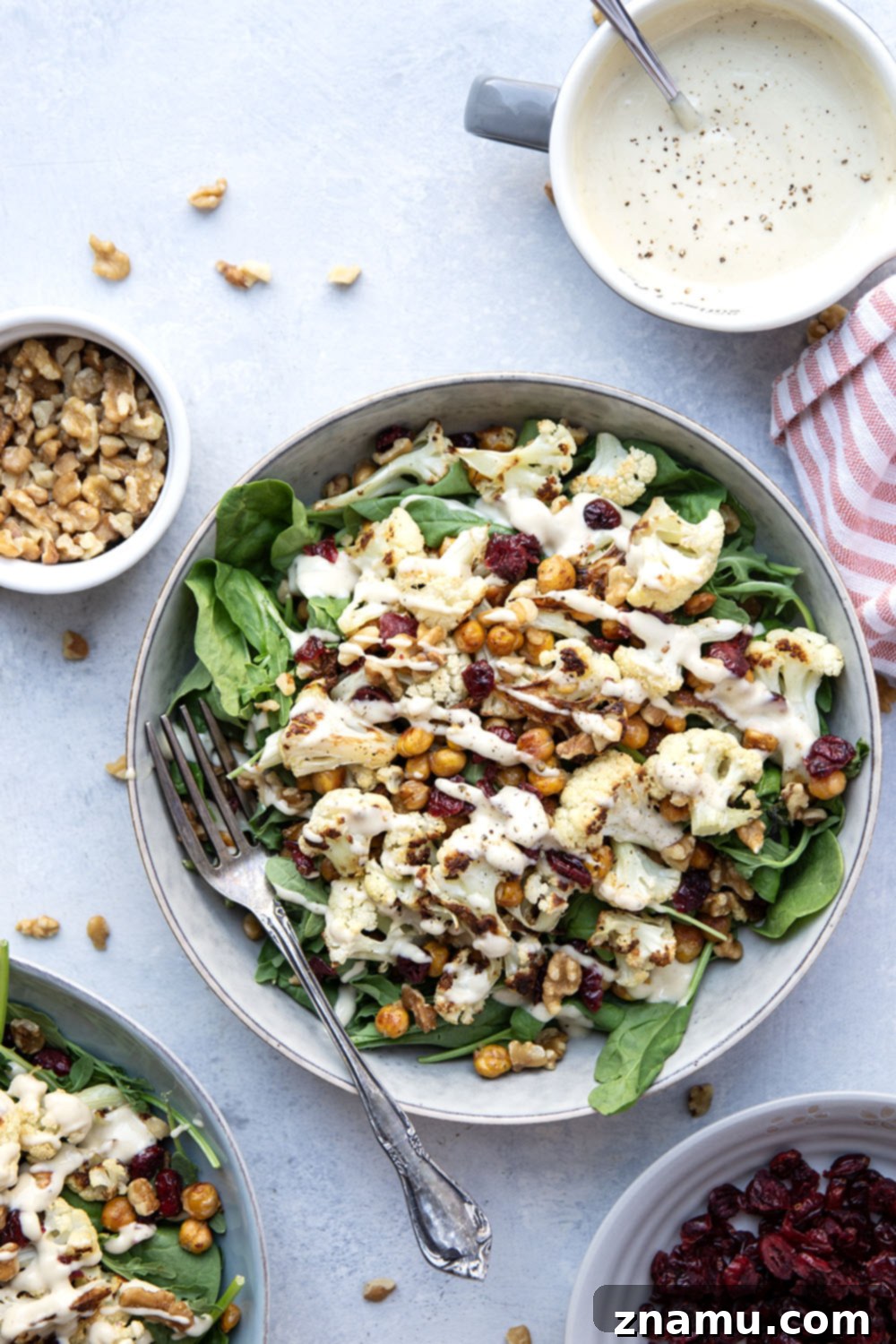 Warm Roasted Cauliflower & Chickpea Salad with Creamy Tahini Dressing 2 Crispy roasted cauliflower and chickpeas and a creamy roasted garlic tahini dressing are the perfect salad combination in this hearty roasted cauliflower chickpea salad.