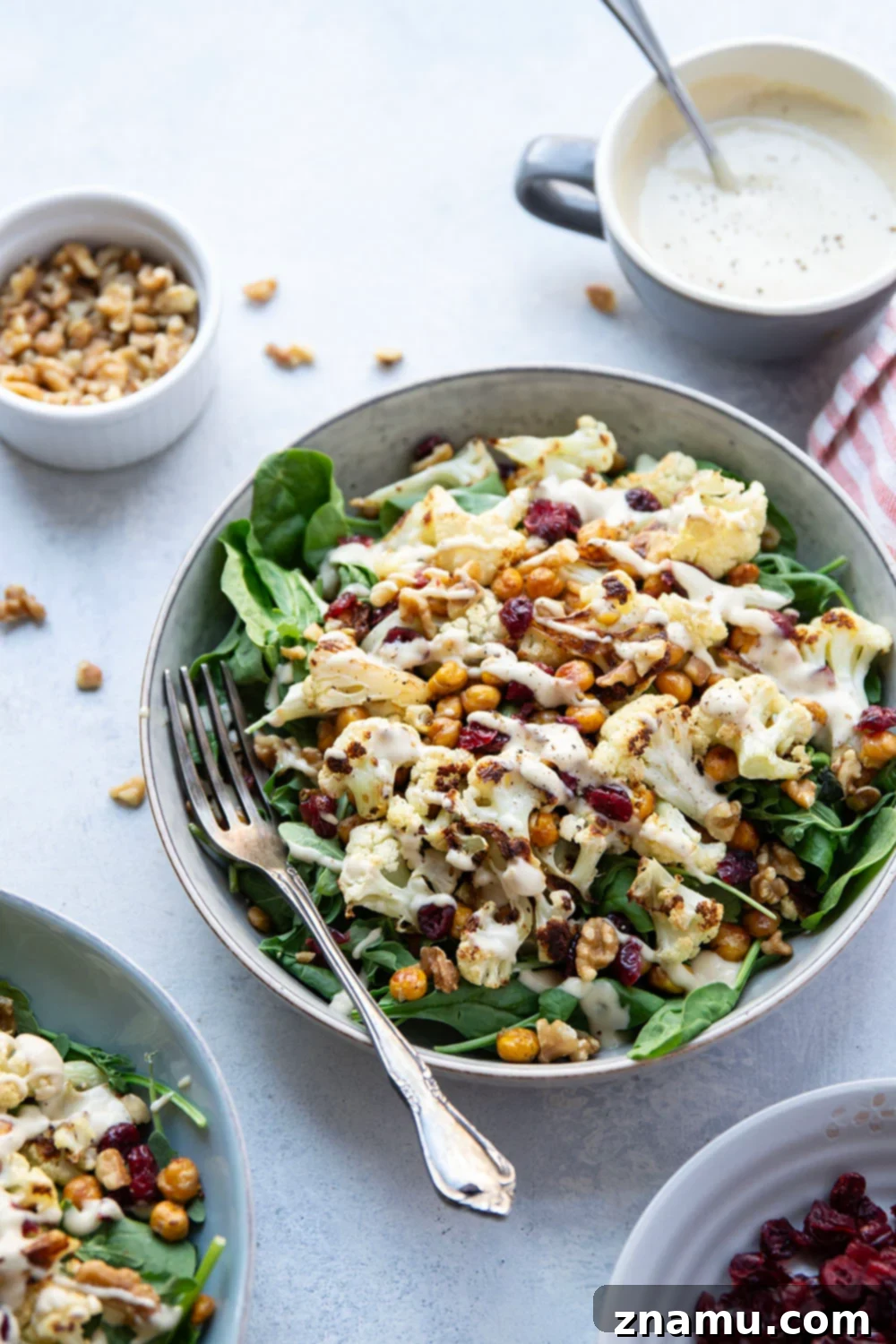 Warm Roasted Cauliflower & Chickpea Salad with Creamy Tahini Dressing 3 Crispy roasted cauliflower and chickpeas and a creamy roasted garlic tahini dressing are the perfect salad combination in this hearty roasted cauliflower chickpea salad.