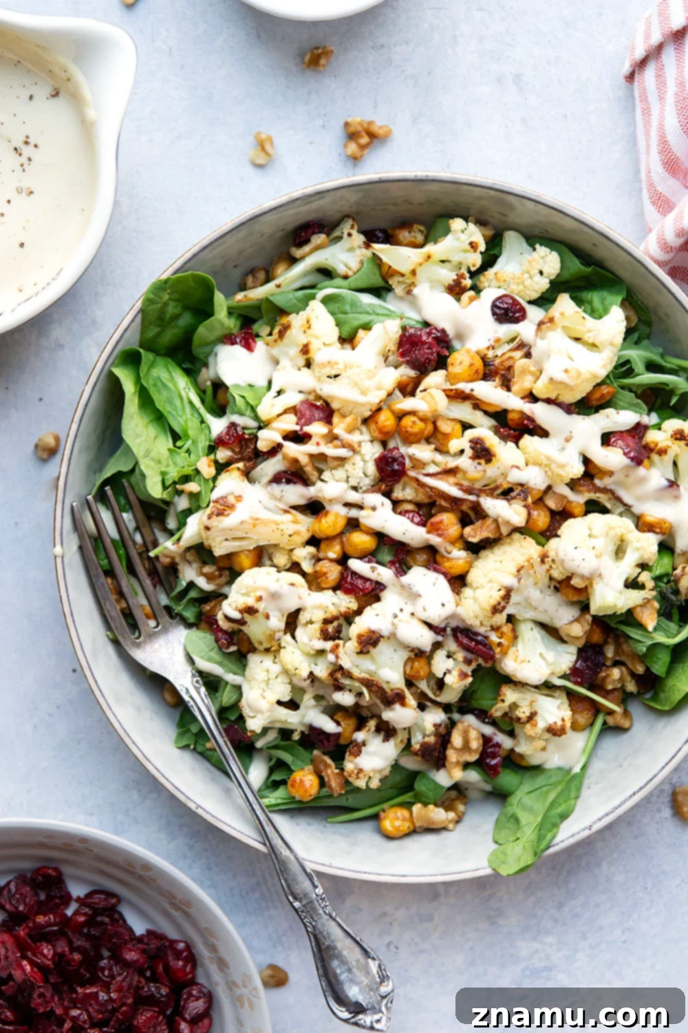 Warm Roasted Cauliflower & Chickpea Salad with Creamy Tahini Dressing 5 Crispy roasted cauliflower and chickpeas and a creamy roasted garlic tahini dressing are the perfect salad combination in this hearty roasted cauliflower chickpea salad.