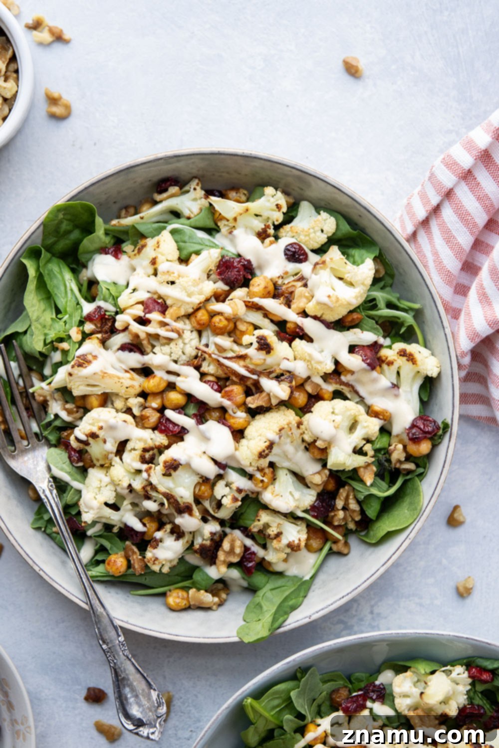 Warm Roasted Cauliflower & Chickpea Salad with Creamy Tahini Dressing 6 Crispy roasted cauliflower and chickpeas and a creamy roasted garlic tahini dressing are the perfect salad combination in this hearty roasted cauliflower chickpea salad.
