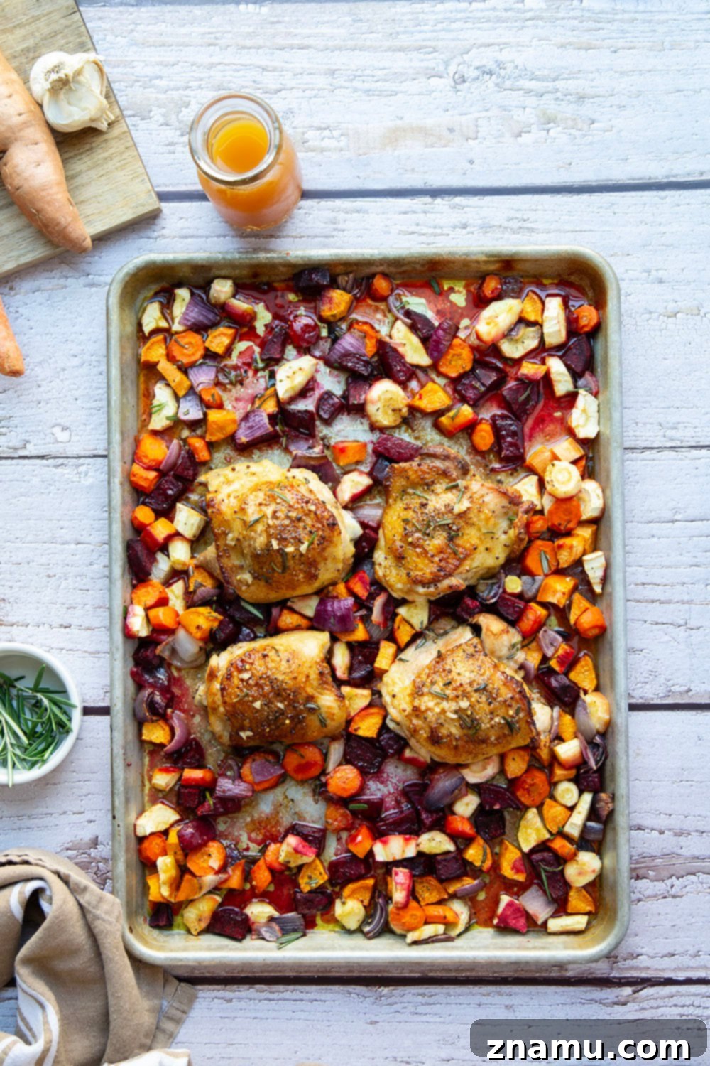 Apple Cider Chicken Thighs and Roasted Roots 3 Close-up of apple cider glazed chicken and colorful root vegetables on a sheet pan.