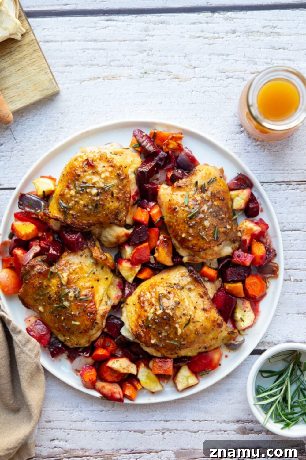 Apple Cider Chicken Thighs and Roasted Roots 6 A serving of apple cider chicken and roasted root vegetables on a plate, ready to eat.