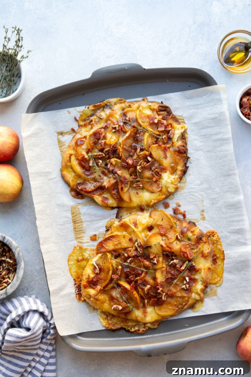 Gourmet Caramelized Apple Brie Flatbread 5 A partially assembled caramelized apple brie flatbread with apples and brie cheese, ready for baking.
