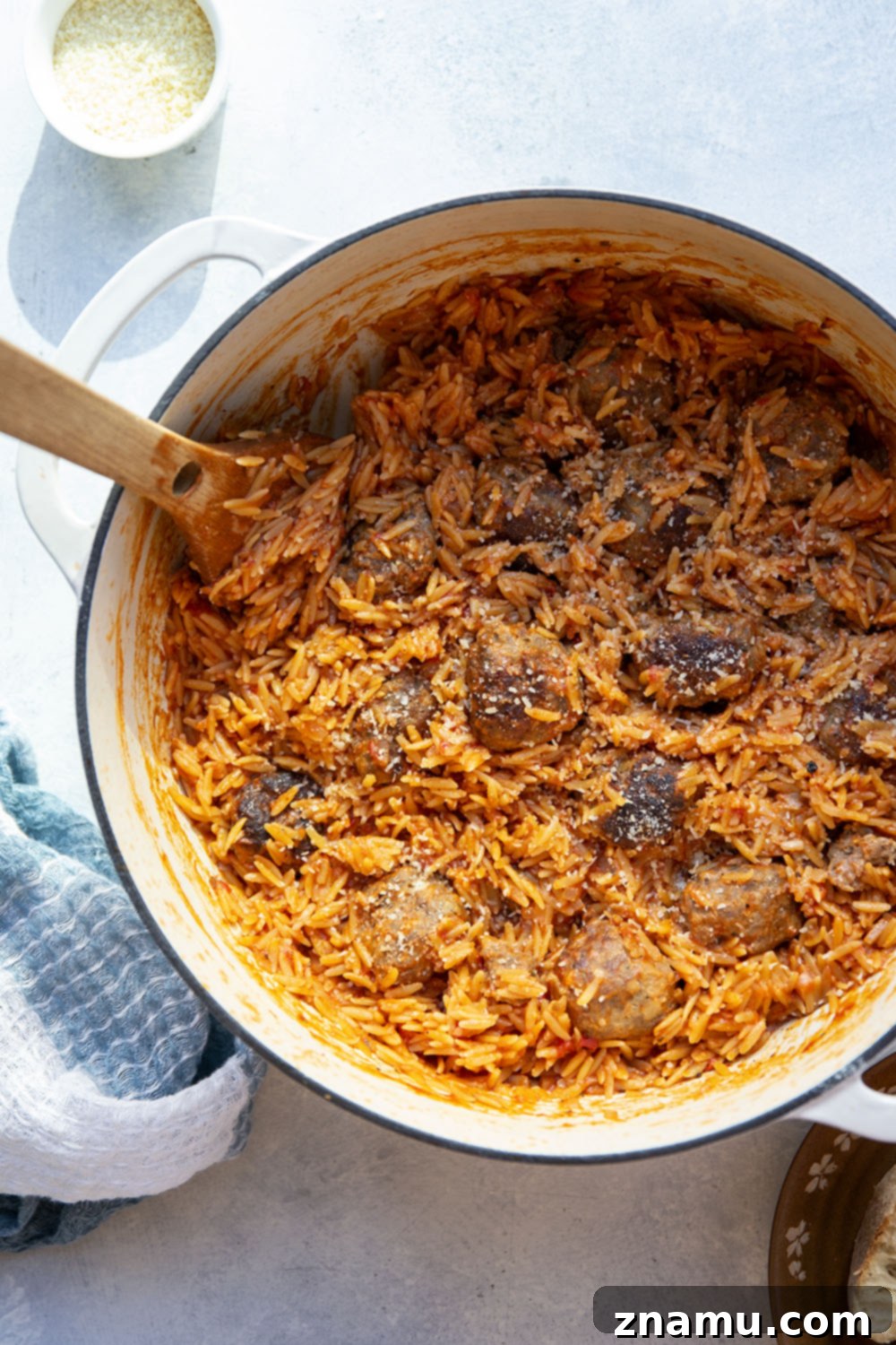 Creamy Vodka Orzo with Meatballs 3 Close-up of juicy meatballs nestled in orzo pasta with a vibrant pink vodka sauce.