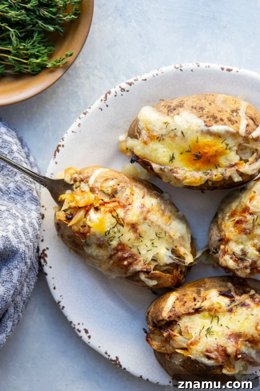Bistro French Onion Baked Potatoes 4 Three prepared French onion baked potatoes arranged on a baking sheet, ready for the oven.