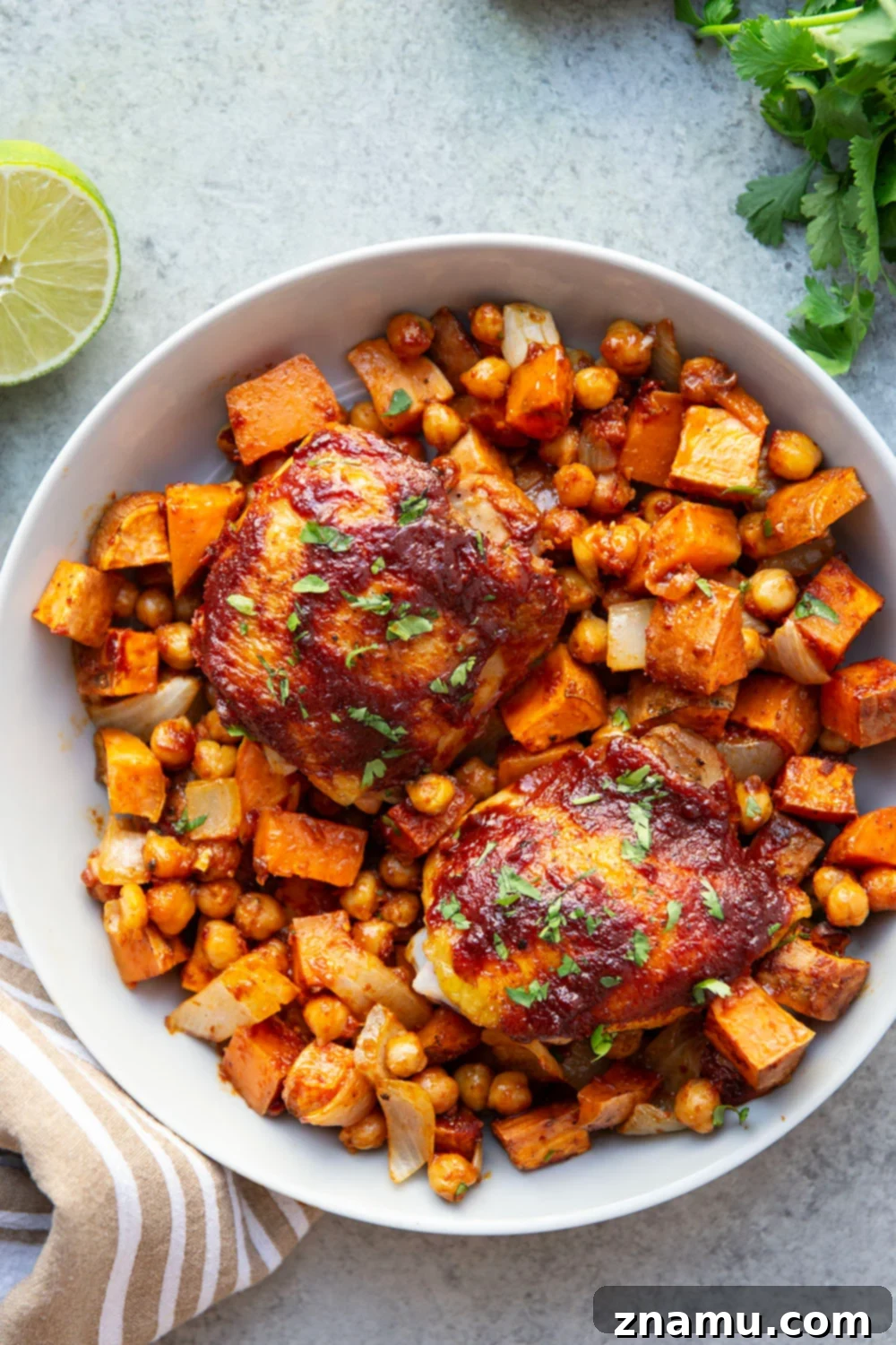 Sheet Pan Harissa Chicken with Roasted Sweet Potatoes & Chickpeas 3 Overhead shot of a colorful sheet pan dinner featuring harissa chicken thighs, sweet potatoes, and chickpeas.