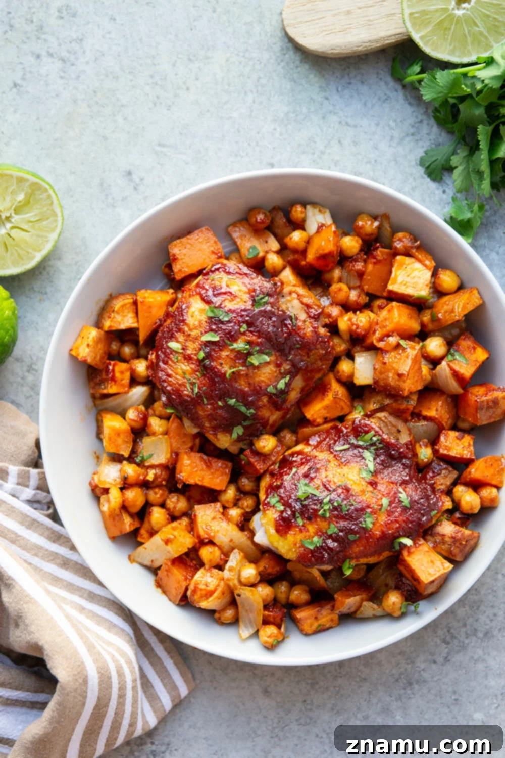 Sheet Pan Harissa Chicken with Roasted Sweet Potatoes & Chickpeas 5 Seasoned harissa chicken thighs ready for cooking on a cutting board.