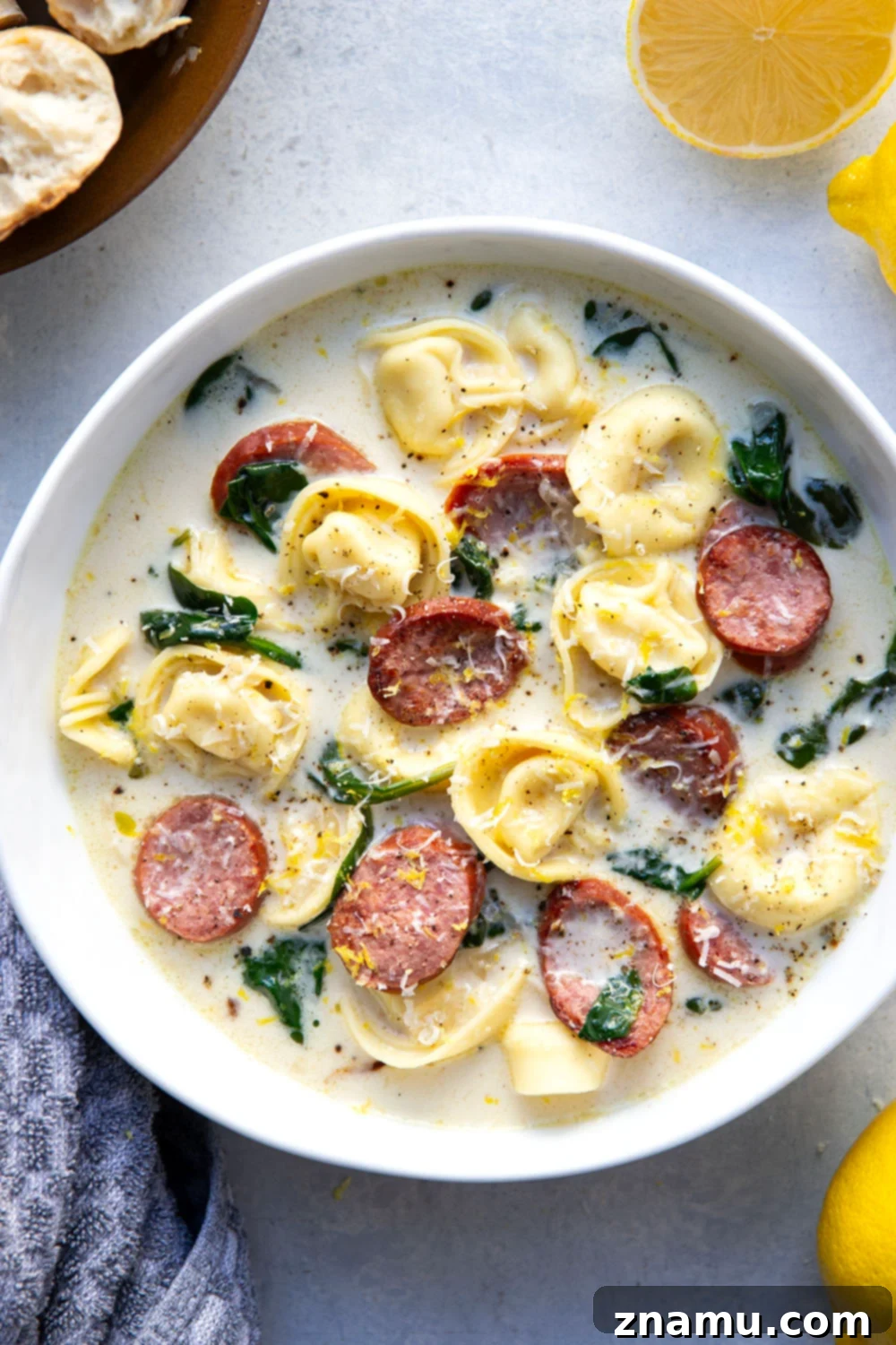 Sunshine Lemon Tortellini Soup 5 Sautéing thinly sliced chicken sausage and chopped yellow onion in a large Dutch oven, creating a fragrant base for the soup.