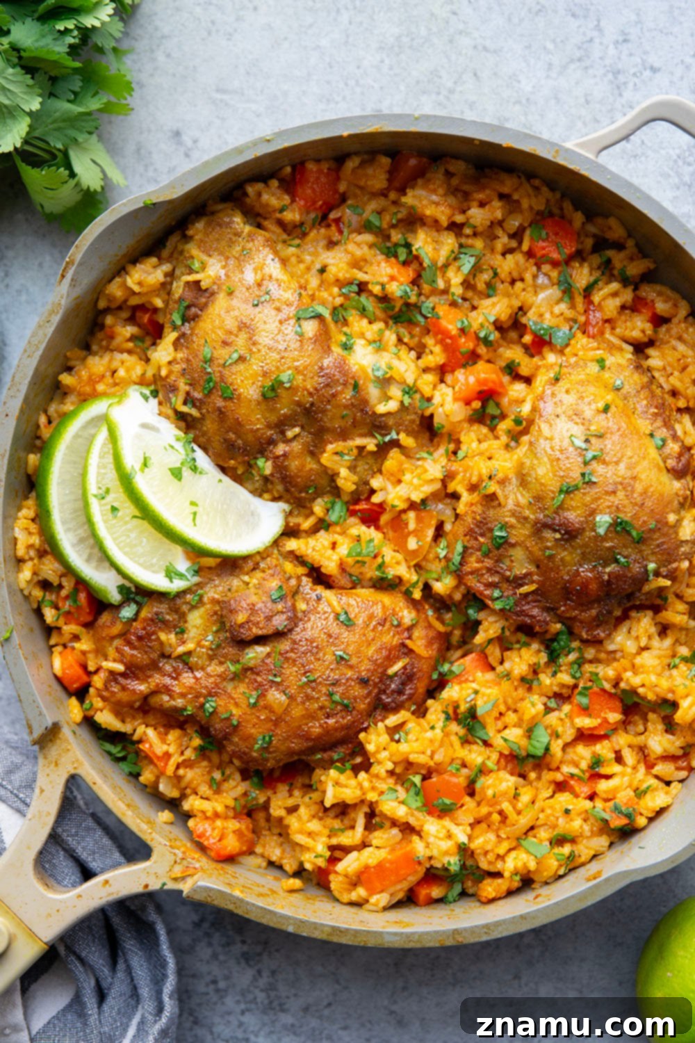 Effortless One-Pan Curry Chicken Dinner 2 A close-up shot of a steaming pot of One Pot Curry Chicken and Rice, showcasing juicy chicken thighs, colorful vegetables, and fluffy, golden curry-spiced rice, garnished with fresh cilantro and a lime wedge.