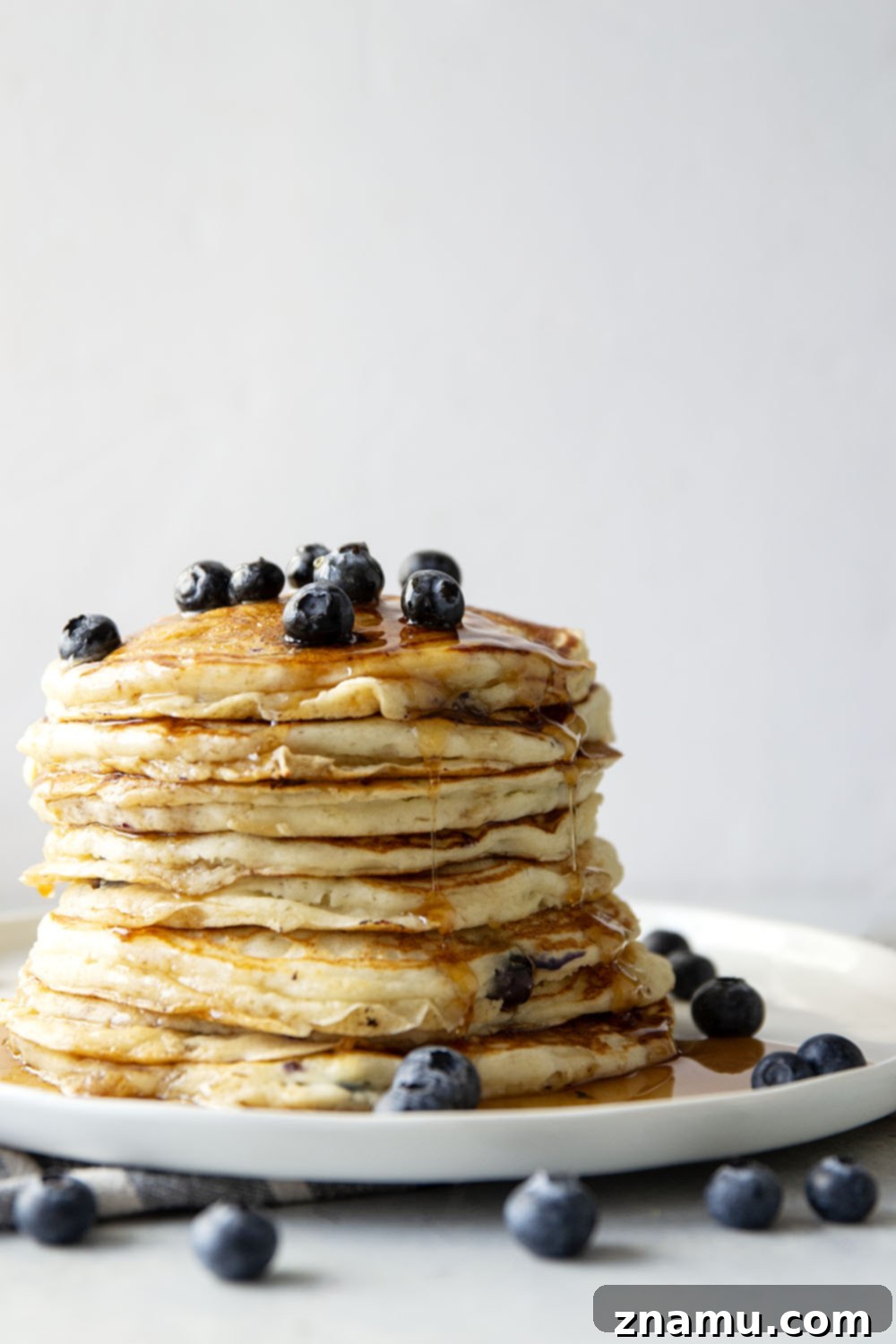 Pillowy Blueberry Ricotta Pancakes 2 Fluffy blueberry ricotta pancakes stacked high with fresh blueberries and maple syrup