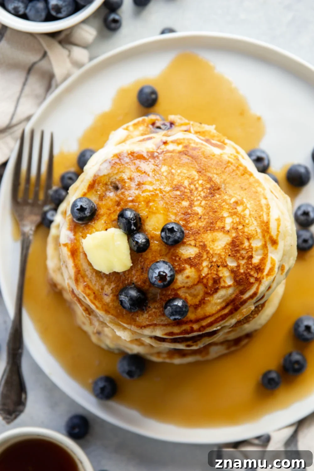 Pillowy Blueberry Ricotta Pancakes 3 Close-up of golden brown blueberry ricotta pancakes with melted butter